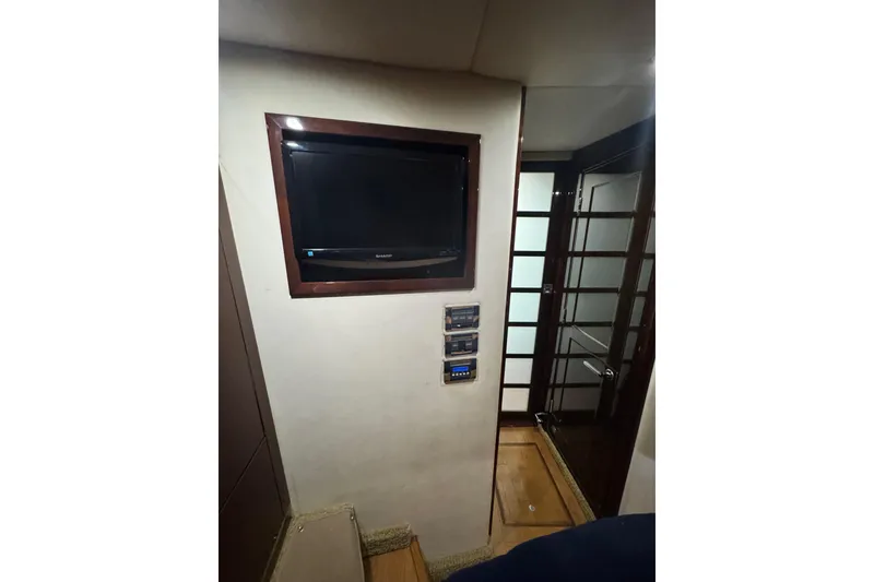 Slide: The Image of Interior of 2009 Sea Ray 470 Sundancer with wall-mounted TV and control panels. - 25