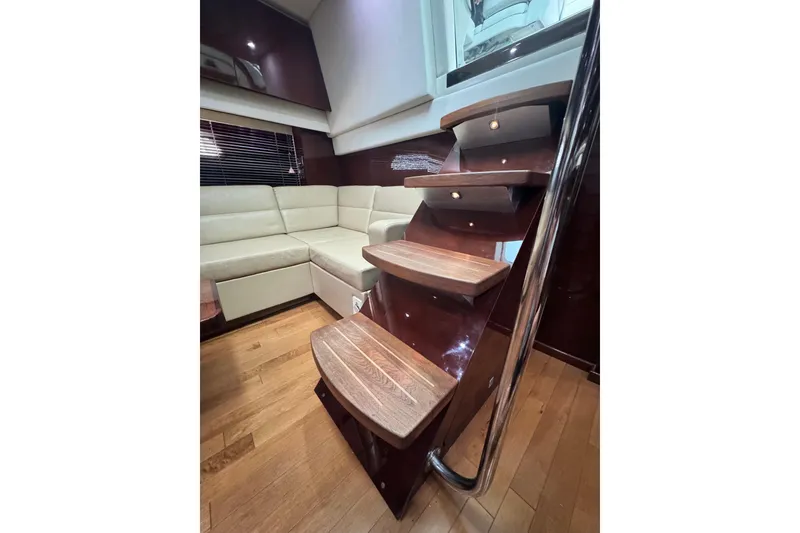 Slide: The Image of Interior of 2009 Sea Ray 470 Sundancer with wooden stairs and cream leather seating. - 34