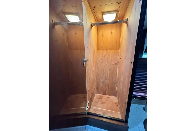 Slide: The Image of Wooden closet interior on 2009 Sea Ray 470 Sundancer yacht, featuring a hanging rod and light. - 42
