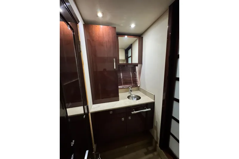 Slide: The Image of 2009 Sea Ray 470 Sundancer bathroom with wooden cabinets and modern sink. - 44