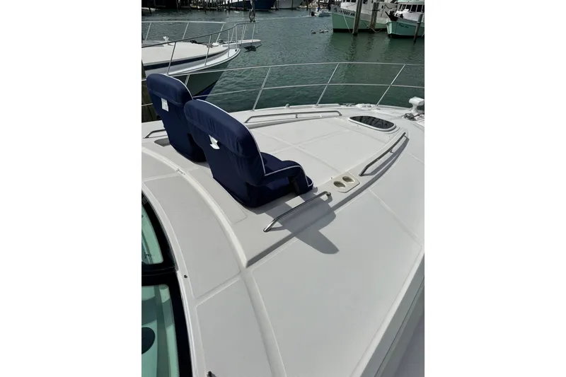 Slide: The Image of 2009 Sea Ray 470 Sundancer yacht with blue deck chairs, docked in marina. - 94