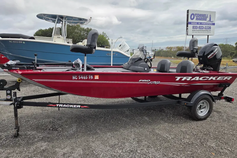 The Image of 2023 Tracker Pro 170 boat in red, parked on a trailer at a marine dealership. - 0