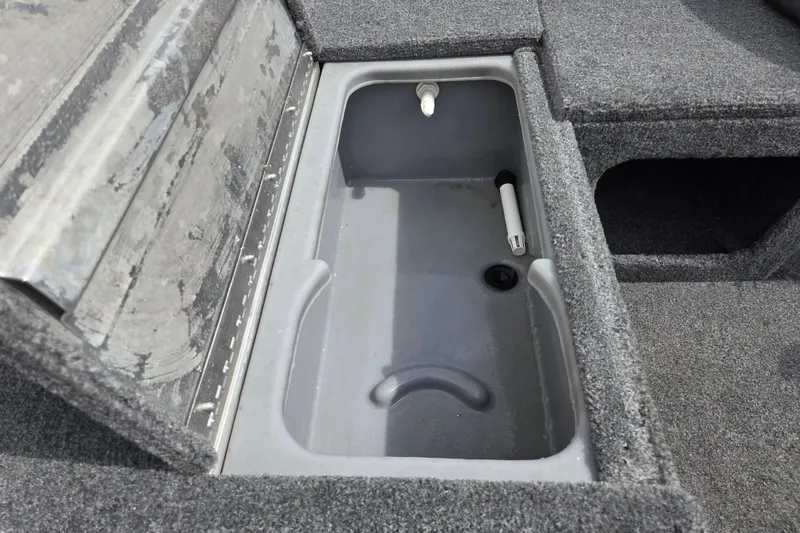 Slide: The Image of 2023 Tracker Pro 170 boat livewell with gray interior and carpeted edges. - 11