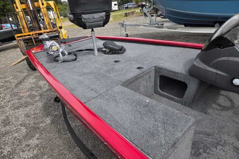 Slide: The Image of 2023 Tracker Pro 170 boat interior with gray carpet and red trim, featuring a seat and storage compartments. - 14