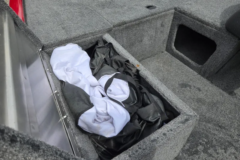 Slide: The Image of Storage compartment in 2023 Tracker Pro 170 boat with gear and clothing. - 7