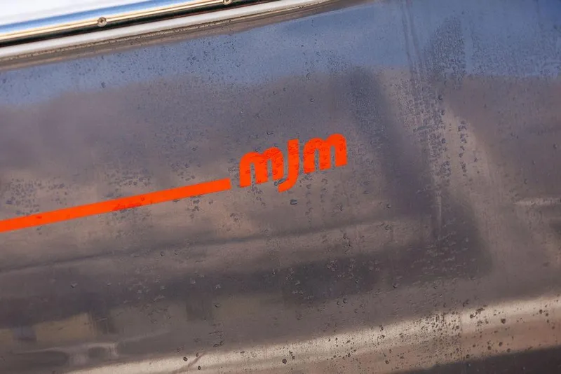 Slide: The Image of Close-up of 2018 MJM 43z boat with red logo on metallic surface. - 12
