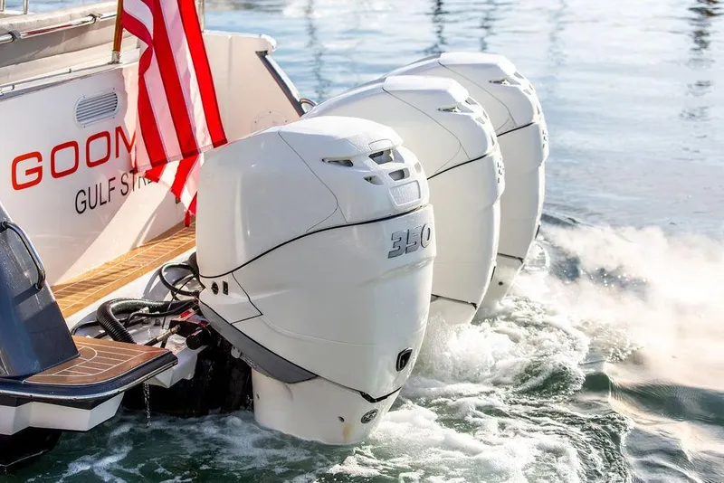 Slide: The Image of 2018 MJM 43z boat with triple 350 horsepower engines, American flag, on water. - 14