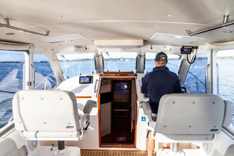 Slide: The Image of Interior view of 2018 MJM 43z boat cockpit with captain navigating. - 19