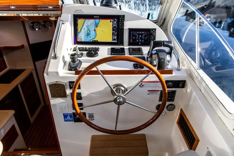 Slide: The Image of Cockpit of 2018 MJM 43z boat with navigation screens and wooden steering wheel. - 24