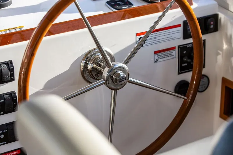 Slide: The Image of Steering wheel of 2018 MJM 43z boat, featuring wood and metal design. - 25
