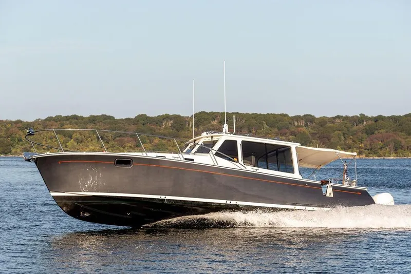 Slide: The Image of 2018 MJM 43z motor yacht cruising on a calm lake with forested shoreline. - 4
