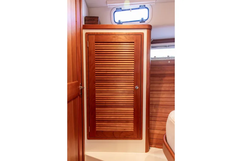 Slide: The Image of Wooden interior of 2018 MJM 43z boat, featuring a louvered cabinet door. - 43
