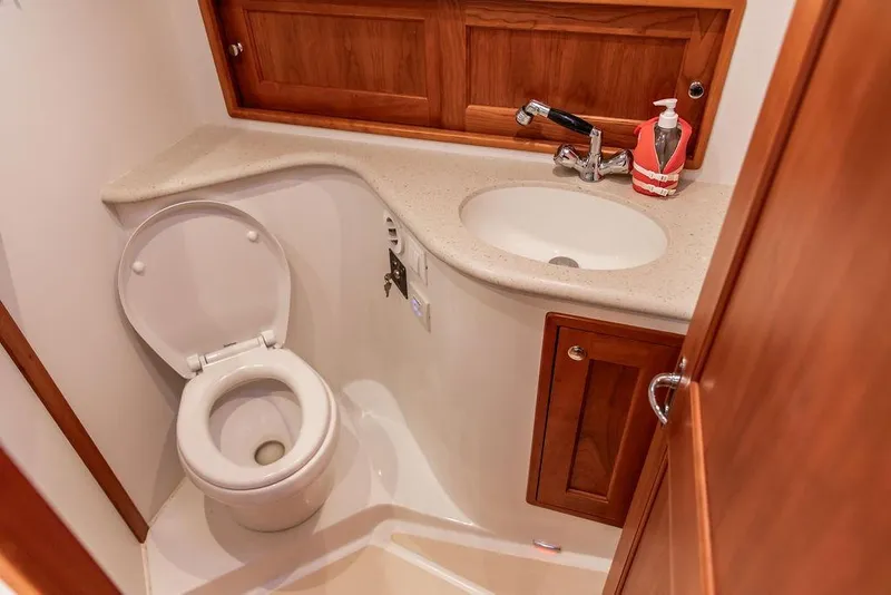 Slide: The Image of 2018 MJM 43z yacht bathroom with toilet, sink, and wooden cabinetry. - 44