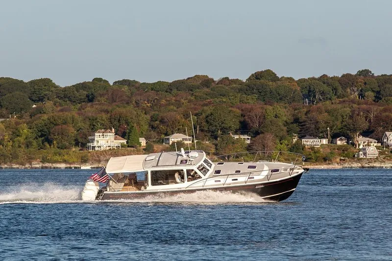 Slide: The Image of 2018 MJM 43z yacht cruising on a scenic lake with lush green shoreline. - 6