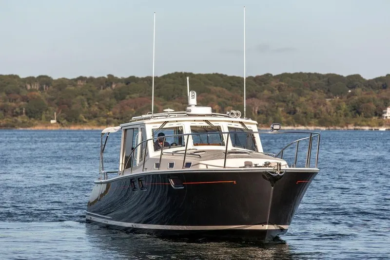 Slide: The Image of 2018 MJM 43z yacht cruising on a serene lake with forested shoreline. - 8