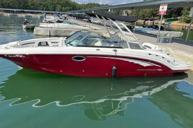 Slide: The Image of 2016 Chaparral 264 Sunesta boat docked on calm water, featuring a sleek red and white design. - 10