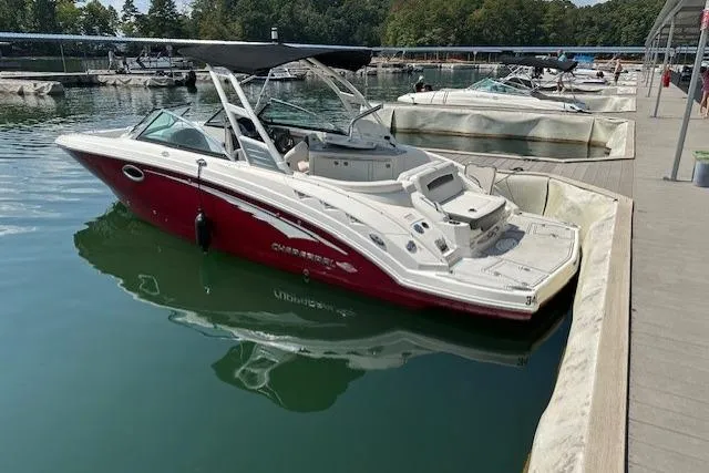 Slide: The Image of 2016 Chaparral 264 Sunesta boat docked in a marina, featuring a sleek red and white design. - 11