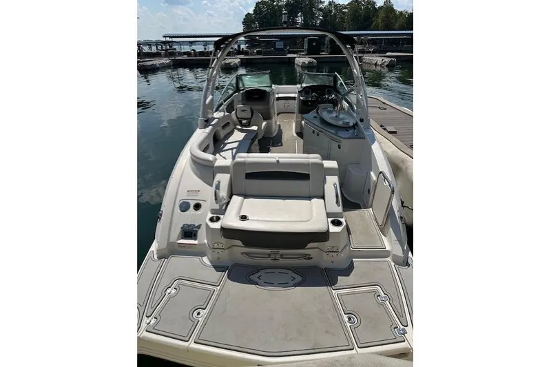Slide: The Image of 2016 Chaparral 264 Sunesta boat interior with seating and helm, docked at marina. - 13