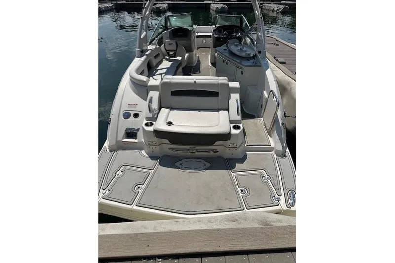 Slide: The Image of 2016 Chaparral 264 Sunesta boat interior with seating and helm, docked on water. - 14