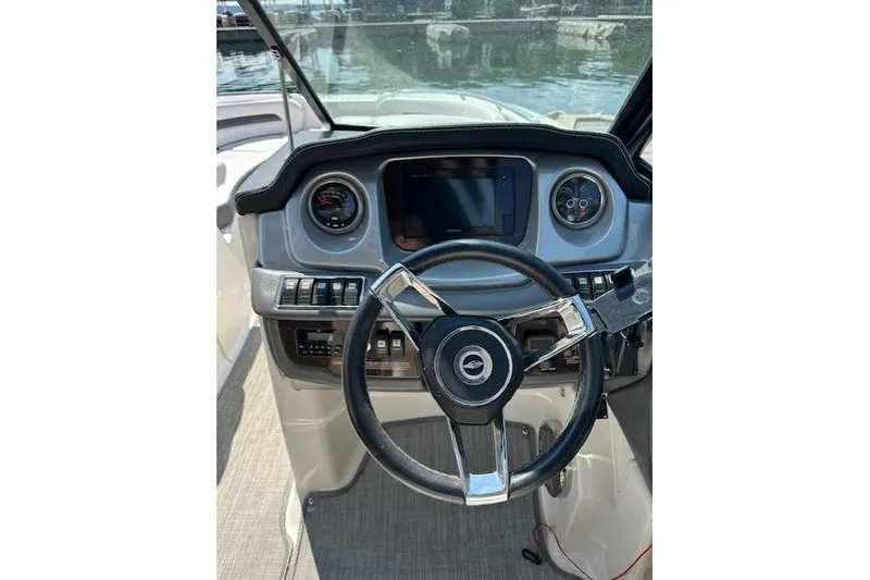 Slide: The Image of 2016 Chaparral 264 Sunesta boat dashboard with steering wheel and controls. - 24