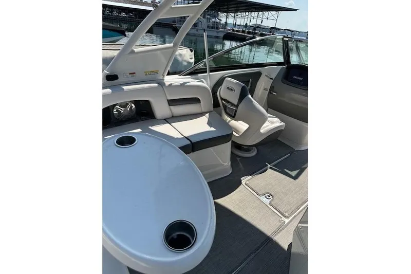 Slide: The Image of 2016 Chaparral 264 Sunesta boat interior with seating and table, docked at marina. - 25