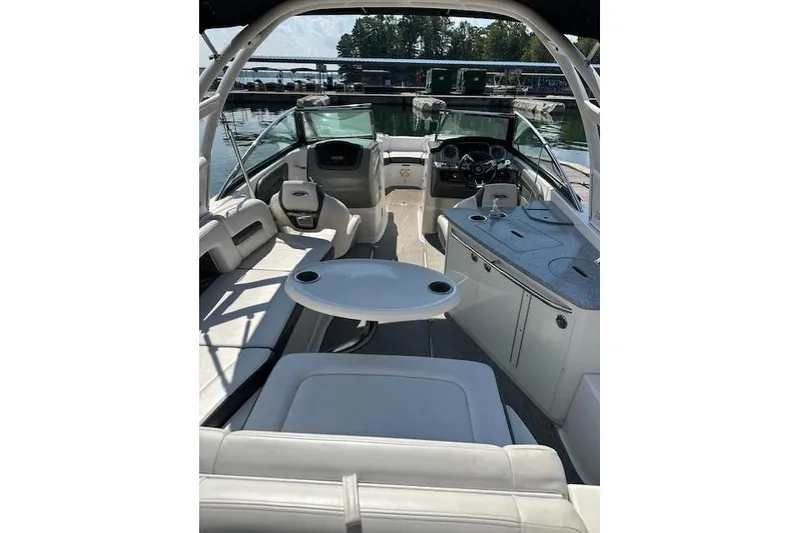 Slide: The Image of 2016 Chaparral 264 Sunesta boat interior with seating and helm, docked at marina. - 27