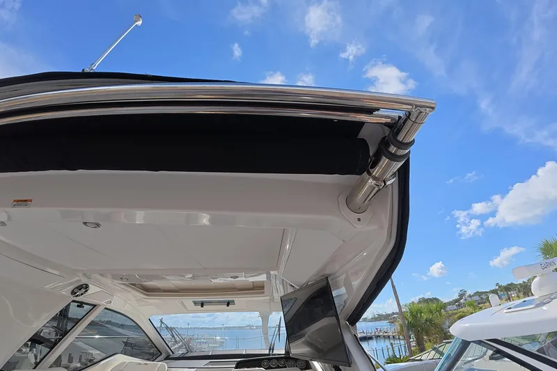 Slide: The Image of 2021 Sea Ray Sundancer 350 Coupe with open sunroof, blue sky background. - 10