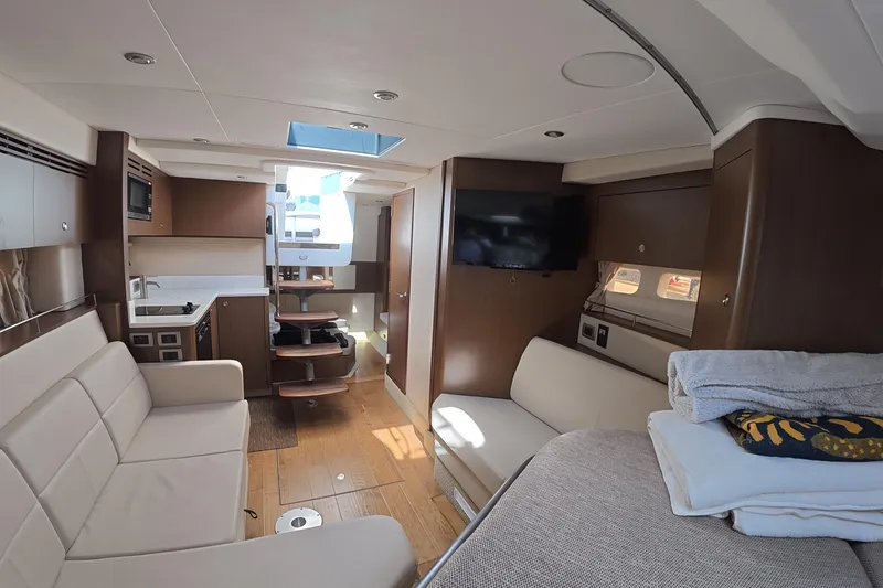 Slide: The Image of Interior of 2021 Sea Ray Sundancer 350 Coupe, featuring modern furnishings and a compact kitchen. - 12