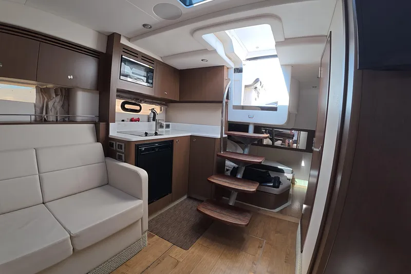 Slide: The Image of Interior of 2021 Sea Ray Sundancer 350 Coupe with modern kitchen and seating area. - 13