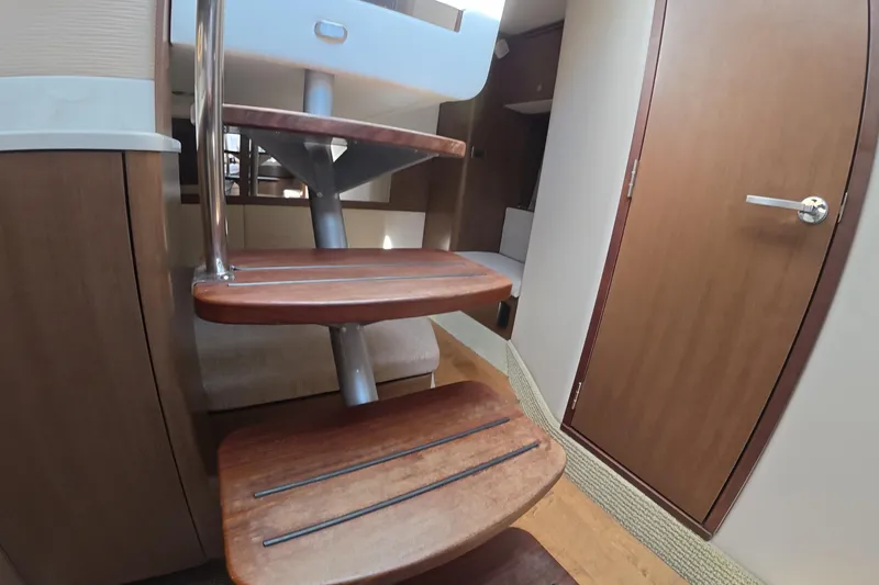 Slide: The Image of Interior of 2021 Sea Ray Sundancer 350 Coupe, featuring wooden stairs and cabin door. - 15