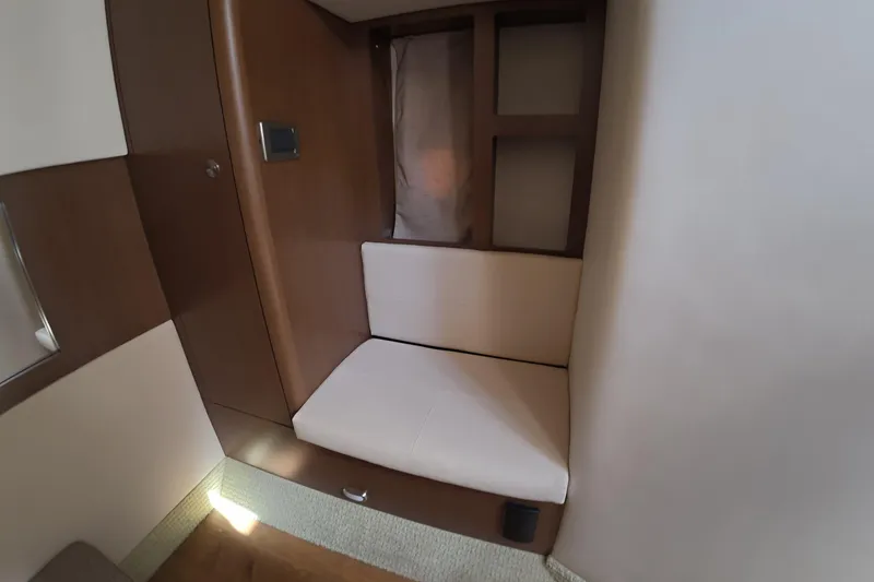 Slide: The Image of 2021 Sea Ray Sundancer 350 Coupe interior seating area with wooden accents and cushioned seat. - 16