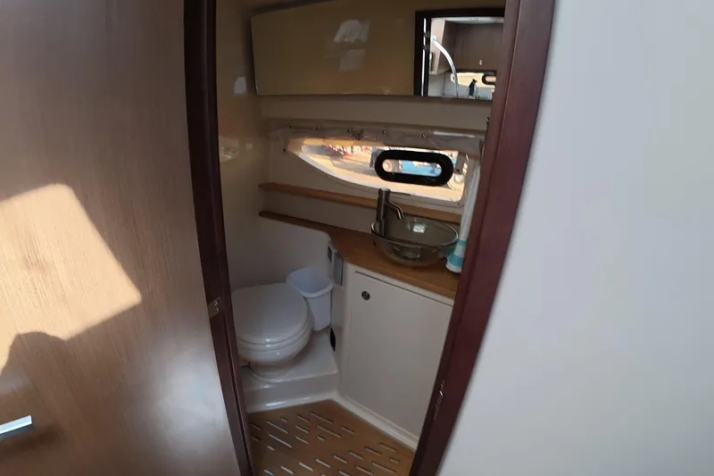 Slide: The Image of 2021 Sea Ray Sundancer 350 Coupe bathroom interior with modern fixtures and wooden accents. - 18