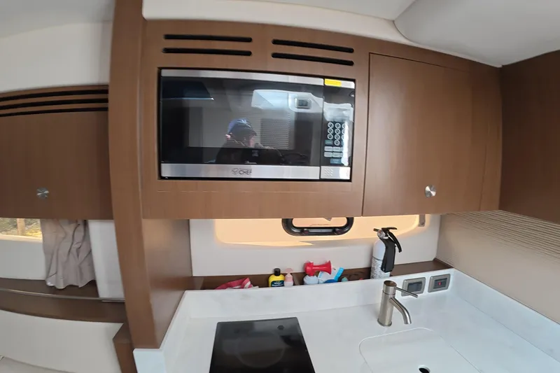 Slide: The Image of Modern kitchen area in 2021 Sea Ray Sundancer 350 Coupe yacht with microwave and sink. - 22