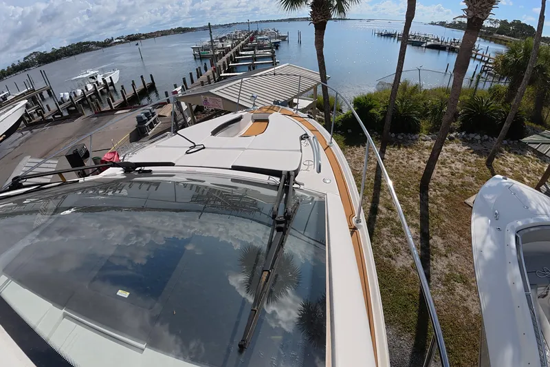 Slide: The Image of 2021 Sea Ray Sundancer 350 Coupe docked at a scenic marina with palm trees. - 26