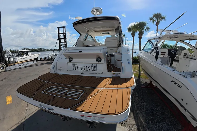 Slide: The Image of 2021 Sea Ray Sundancer 350 Coupe docked, showcasing elegant design and spacious deck. - 5