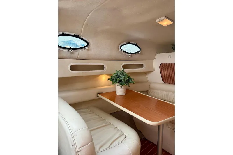 Slide: The Image of Interior of 1999 Monterey 296 Cruiser with cozy seating and wooden table. - 10