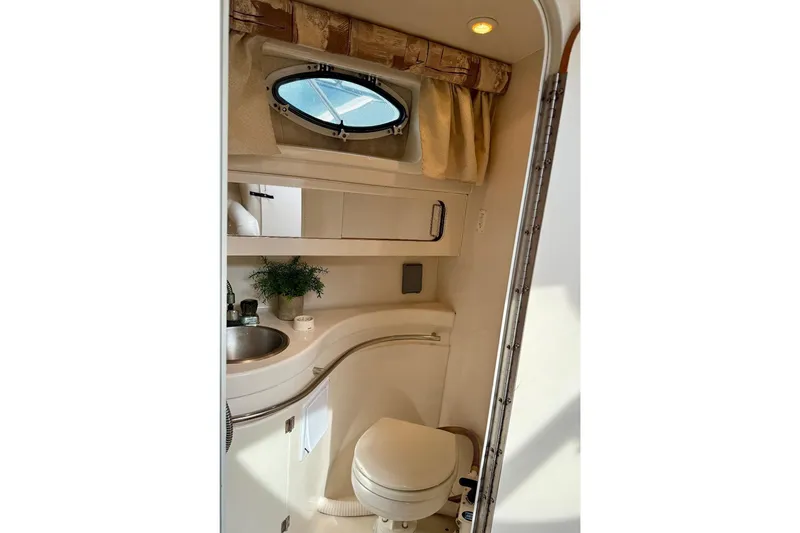 Slide: The Image of 1999 Monterey 296 Cruiser bathroom with sink, toilet, and porthole window. - 7