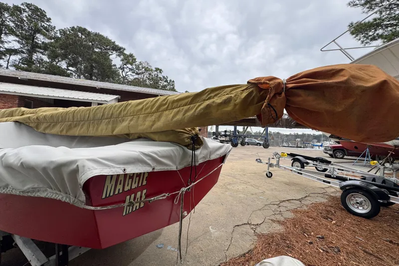 Slide: The Image of 1986 One Design Point Jude 16 sailboat with covered mast, named "Maggie Mae," on a trailer. - 11