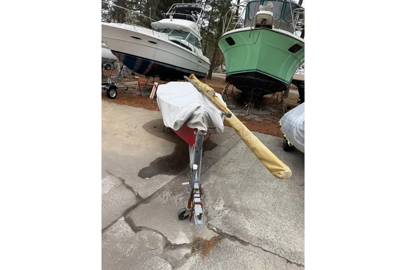 Slide: The Image of Covered 1986 One Design Point Jude 16 sailboat on trailer, surrounded by other boats. - 13