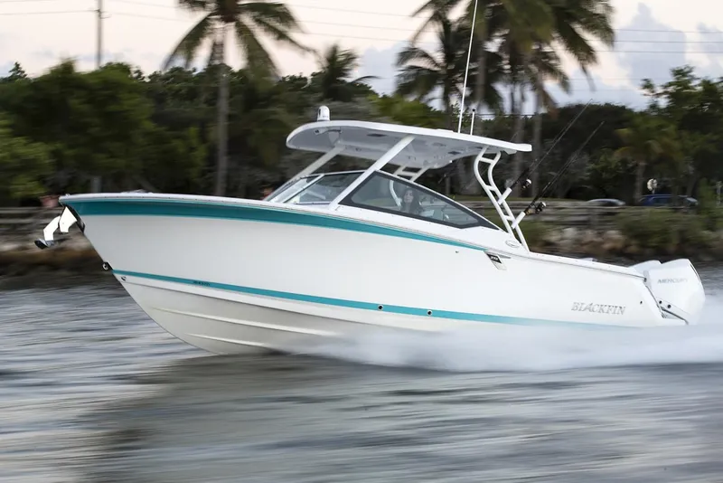 The Image of Manufacturer Provided Image: 2026 Blackfin 272 DC boat cruising on water with palm trees in background. - 0