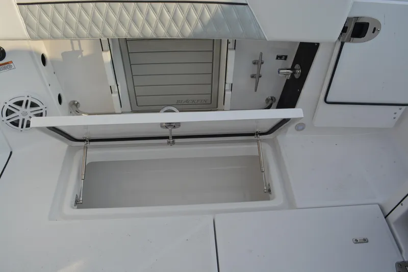 Slide: The Image of 2026 Blackfin 272 DC boat interior with open storage compartment and sleek design. - 23