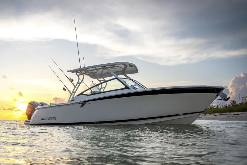 Slide: The Image of Manufacturer Provided Image: 2026 Blackfin 272 DC boat on water at sunset, showcasing sleek design and fishing rods. - 3