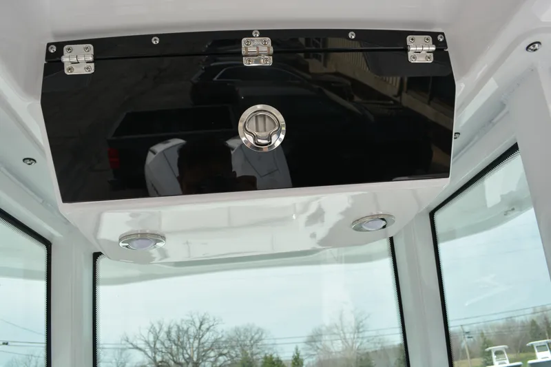 Slide: The Image of 2026 Blackfin 252 CC boat interior storage compartment with sleek black finish and secure latch. - 10