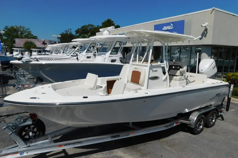 The Image of 2026 Pathfinder 2400 TRS boat on trailer at dealership, sunny day. - 0