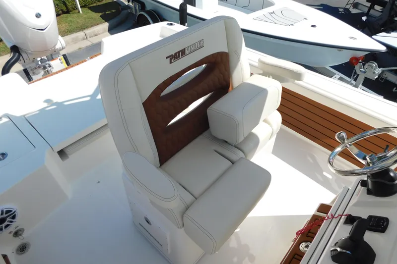 Slide: The Image of 2026 Pathfinder 2400 TRS boat interior with luxurious seating and steering wheel. - 13