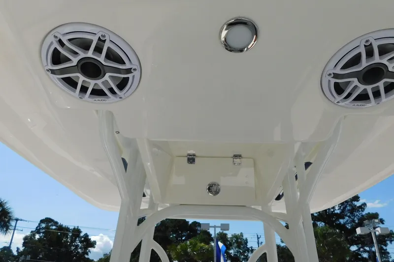 Slide: The Image of 2026 Pathfinder 2400 TRS boat speakers and lighting under T-top, clear sky background. - 15