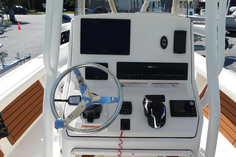 Slide: The Image of 2026 Pathfinder 2400 TRS boat console with steering wheel and navigation controls. - 2