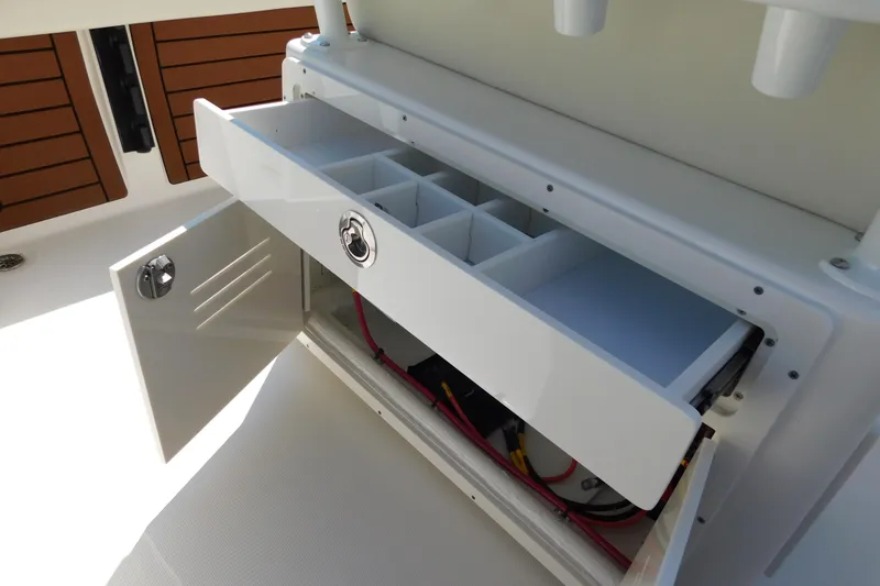 Slide: The Image of 2026 Pathfinder 2400 TRS boat storage compartment with open drawer and wiring. - 25