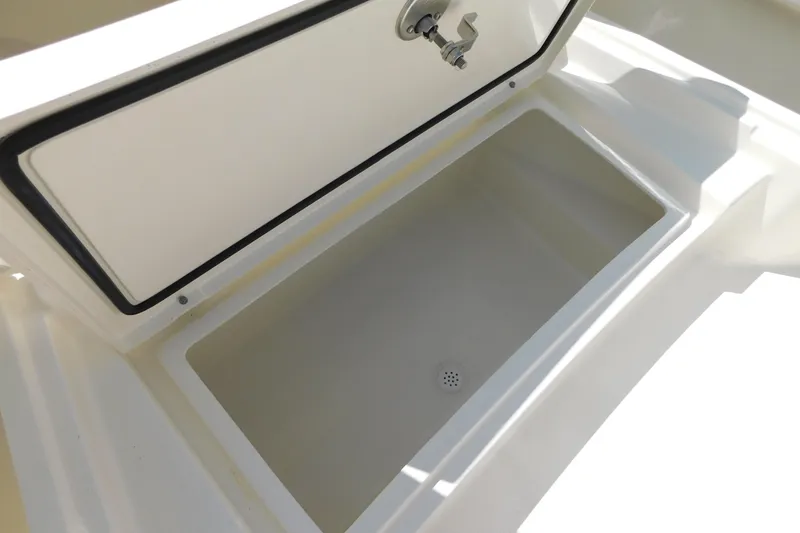 Slide: The Image of Open storage compartment on 2026 Pathfinder 2400 TRS boat, featuring a drain plug. - 29
