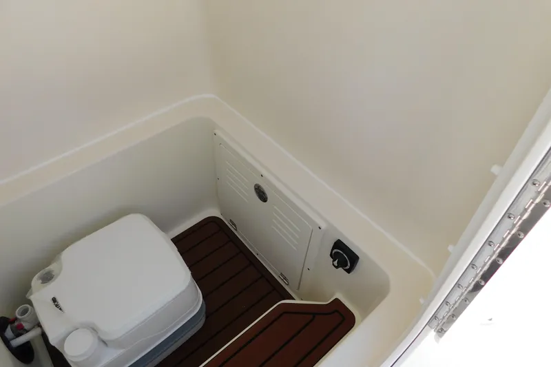 Slide: The Image of 2026 Pathfinder 2400 TRS boat interior with compact toilet and storage area. - 37
